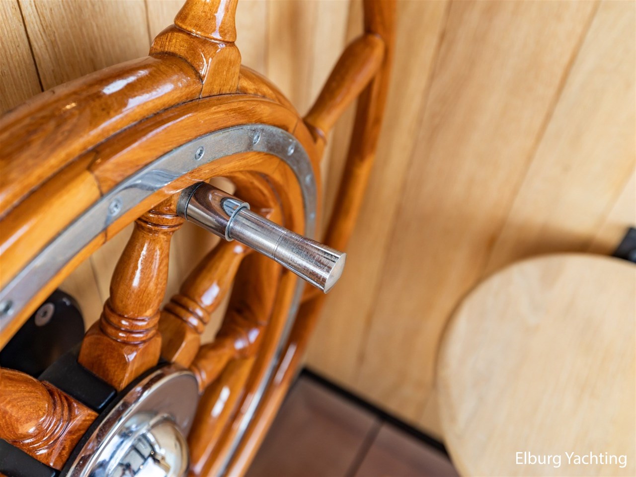 Het houten stuurwiel van dichtbij, met de metalen handgrepen en bedieningsdetails.