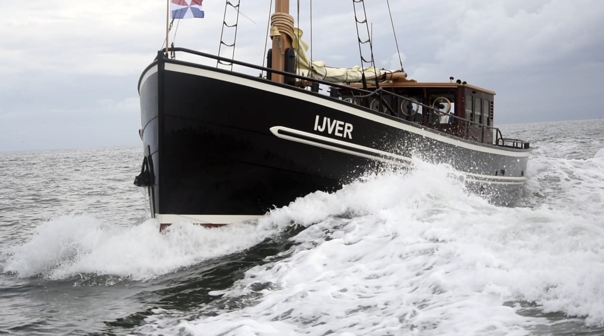 Motorjacht IJver met klassieke boeg op het water